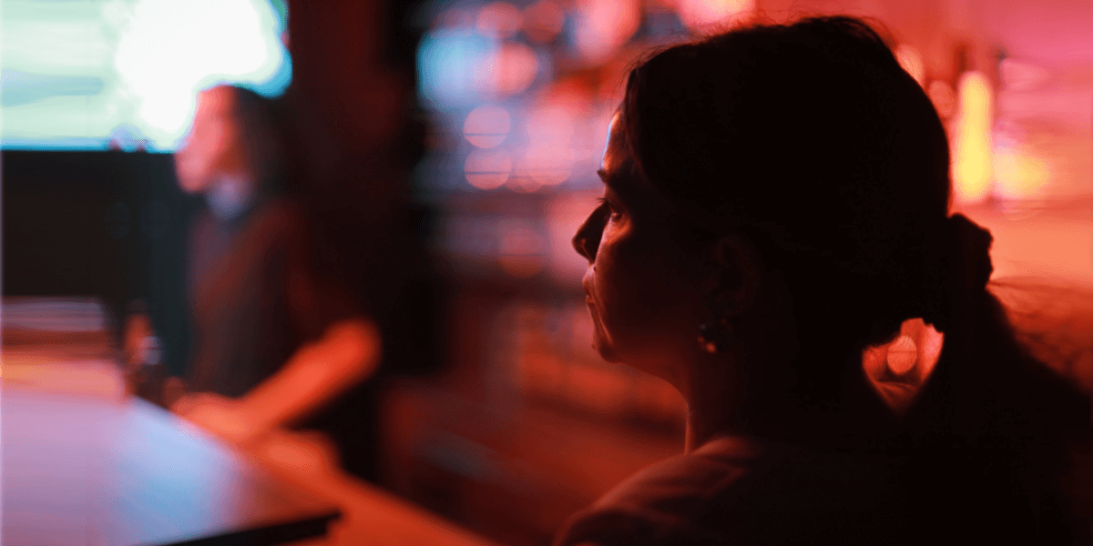 woman sitting in a dimly lit bar