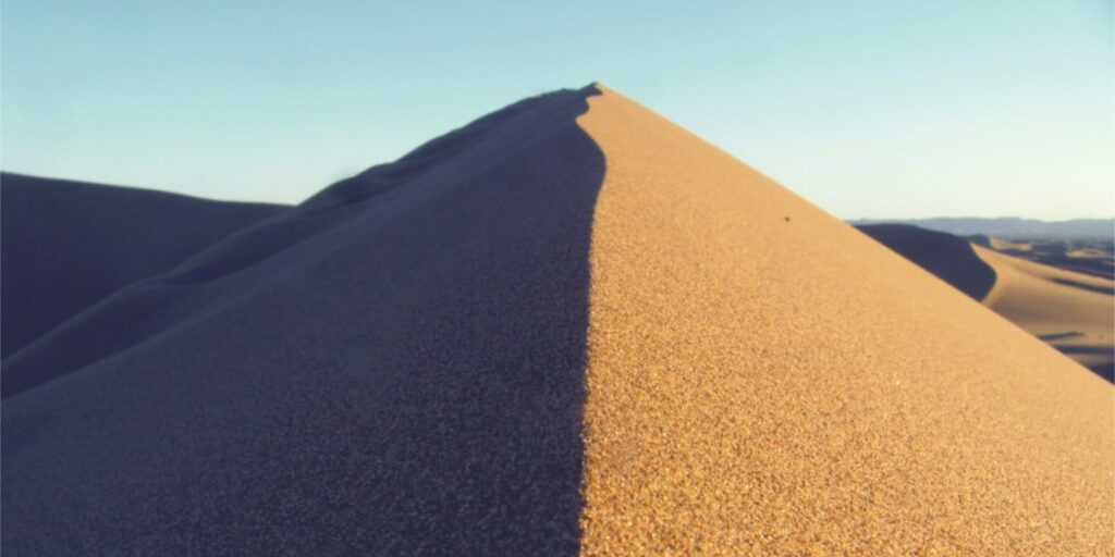 sand dune with split shadow depicting psychedelic vs. psychiatric medicine for the treatment of mood disorders