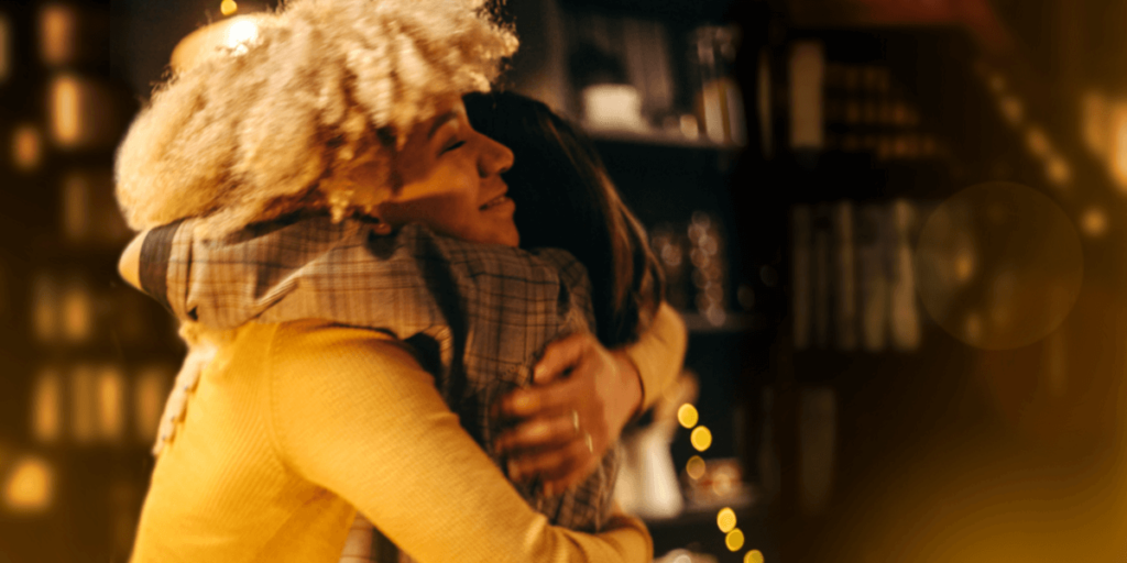 two women happily connect through a hug, addressing America's loneliness epidemic